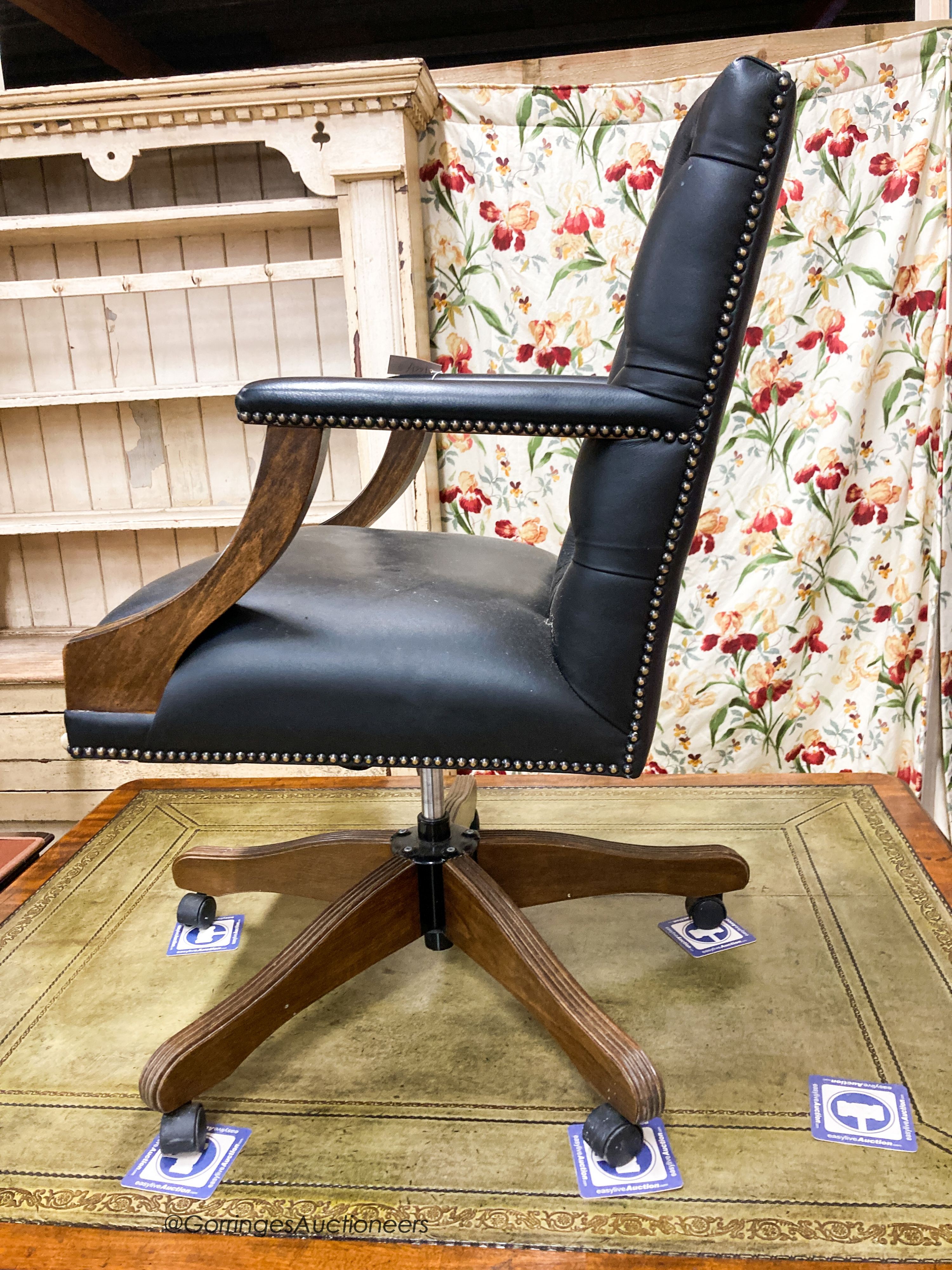 A reproduction beech buttoned blue leather swivel desk chair, W.54cm. D.61cm H.99cm